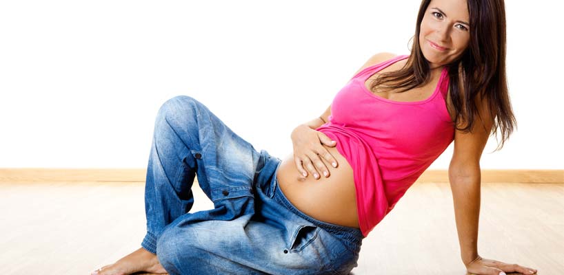 gravid kvinde sidder på gulv