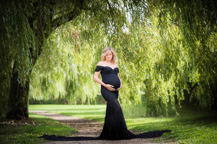 gravid kvinde i sort kjole i skov