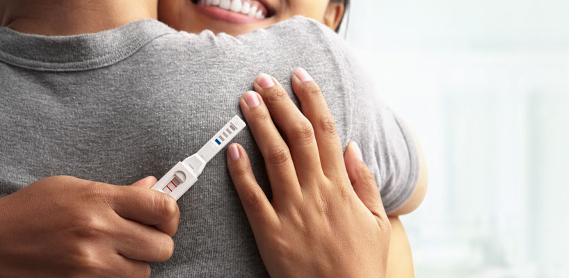 gravid kvinde omfavner mand