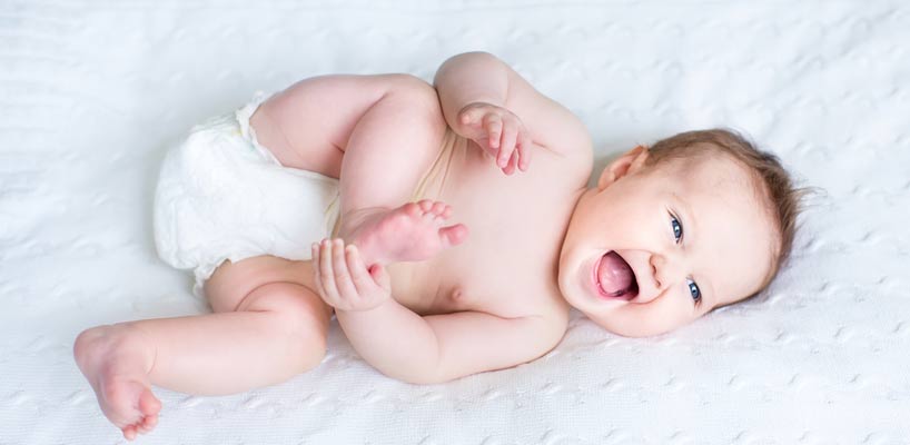 glad baby ligger på ryggen