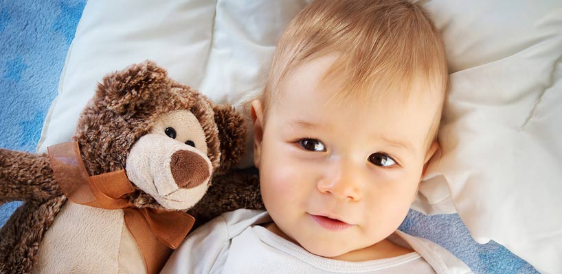 baby ligger sammen med tøjbamse
