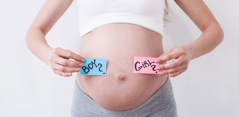 gravid kvinde med girl eller boy skilte