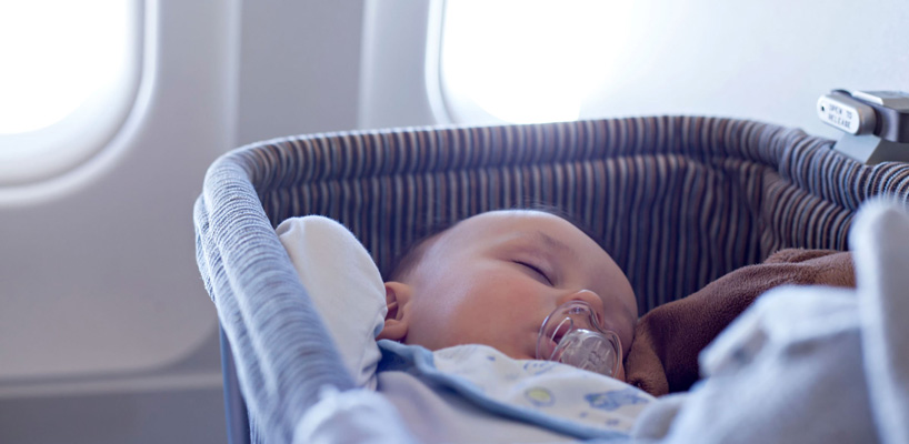 Baby sover i vugge i fly